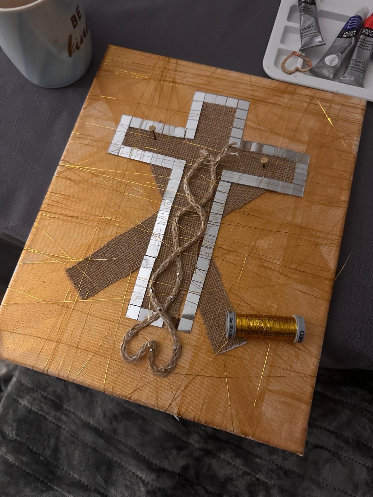 The Weaver, a woven cross of twine and gold